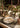 A Christmas celebration table setting in a wooden cabin decorated with gifts around the table, antique objects, and handwoven textiles.