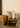 A neutral colour palette stack of pillows in a traditional-inspired room decorated with woven bamboo basket and wooden bench.